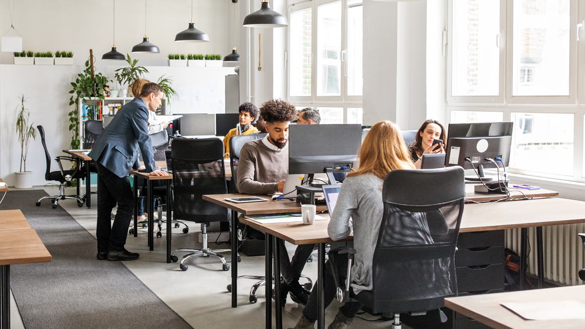 Menschen arbeiten gemeinsam in einem modernen, hellen Großraumbüro