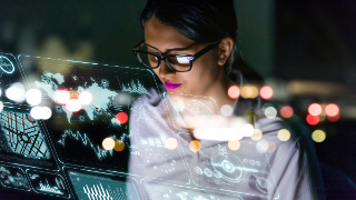 Person betrachtet digitale Benutzeroberfläche mit Datenvisualisierungen und Weltkarten.